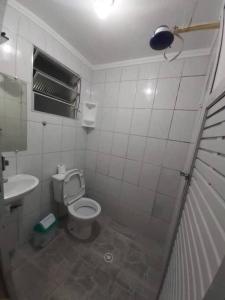 a small bathroom with a toilet and a sink at Casa com Piscina na Enseada in Guarujá +4 photos