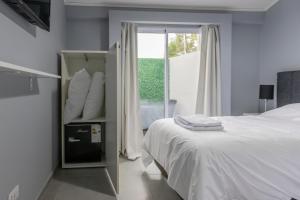 ein Schlafzimmer mit einem weißen Bett und einem Fenster in der Unterkunft La Casona Apart & Suites in Ezeiza