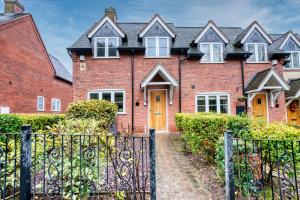 a red brick house with a black gate at NEC Birmingham Airport Modern Village Retreat, Sleeps 7, Free Parking in Hampton in Arden