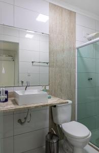un bagno con lavandino, WC e specchio di 2 suítes a 500m da Praia dos Milionários a Ilhéus