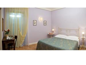 a bedroom with a bed and a table and a window at Il Borgo del Fattore B&B in Foligno