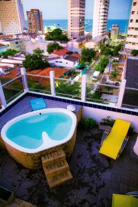 a bath tub on a building with a view of a city at Hotel Casa De Praia in Fortaleza