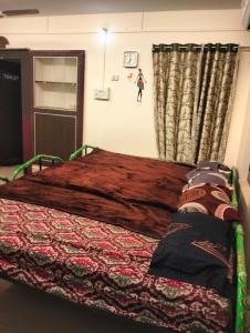 1 dormitorio con cama con colcha en Aadhiran temple view room, en Tiruvannāmalai