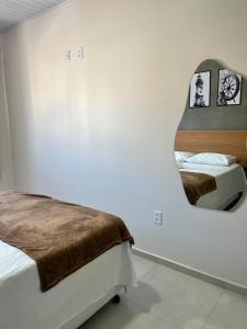 a bedroom with two beds and a mirror at LOFT PAJUMAR 1 ANDAR 300mt PRAIA PAJUCARA in Maceió