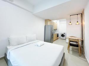 une chambre blanche avec un grand lit et une table dans l'établissement The Colony Infinitum By Happy Stay, à Kuala Lumpur