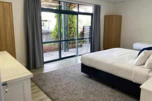 En eller flere senge i et værelse på Deluxe 280sqm 3 bedroom with Pool Table - 200m to beach