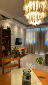 un salon avec une table et un lustre dans l'établissement Casa encantadora com vista para o lago, à Cabo Frio