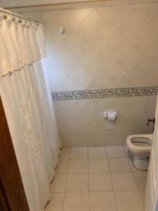 a bathroom with a toilet and a shower curtain at Casa Quinta para Descansar en Mercedes in Mercedes +21 photos