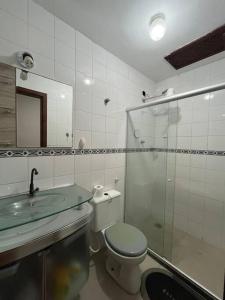 une salle de bain avec toilettes et douche en verre dans l'établissement Casa encantadora com vista para o lago, à Cabo Frio