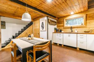eine Küche mit einem Tisch und Stühlen sowie eine Treppe in der Unterkunft Le 14 Chalets Howard - Spa-Shower-Hammock-Bromont in Bromont