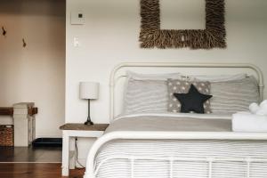 a bedroom with a white bed with a black star on it at Chalet Chti - bord de l'eau mont Orford in Eastman