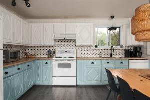 a kitchen with blue cabinets and a white stove top oven at Chalet Chti - bord de l'eau mont Orford in Eastman