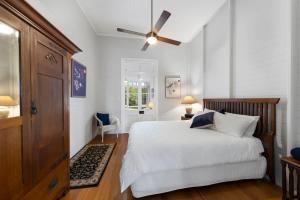 Un dormitorio con una cama y un ventilador de techo. en The Little Queenslander - Maleny Circa 1888, en Balmoral Ridge