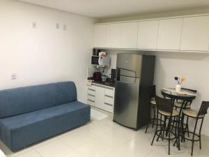 a living room with a couch and a kitchen with a table at Suite costa in Capitólio