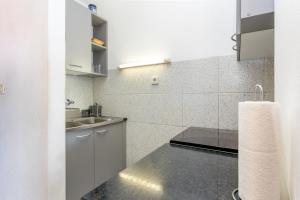 a white kitchen with a sink and a counter at Apartments by the sea Postira, Brac - 739 in Postira +31 photos