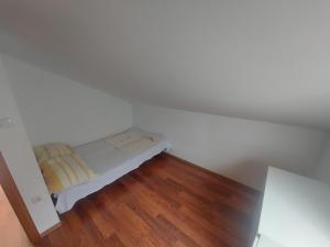Cette petite chambre blanche dispose d'un lit et de parquet. dans l'établissement Apartments by the sea Mandre, Pag - 6507, à Kolan