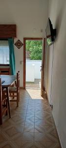 a dining room with a table and a television on the wall at El nuevo amanecer mar de ajó in Mar de Ajó