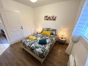 une chambre avec un lit avec des oreillers jaunes dessus dans l'établissement Apartment in Carantec near Sandy Beaches, à Carantec