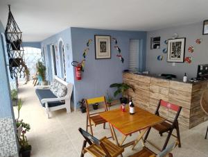 a living room with a wooden table and chairs at Pousada Aconchego na Praia in Praia Grande