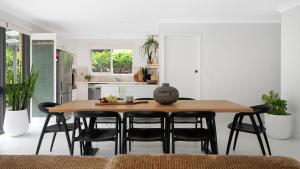 a kitchen with a wooden table and black chairs at Kabina 98 in Callala Beach