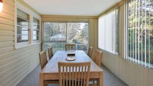 a porch with a wooden table and chairs on it at Balgownie Cottage in Blackheath