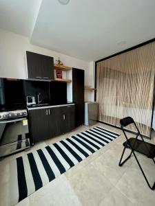 Habitación con cocina con silla y alfombra. en Aparta-Suite en Garagoa ubicación central., en Garagoa