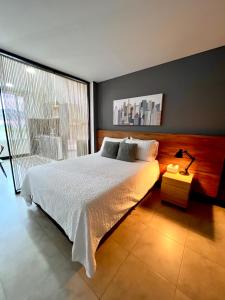Un dormitorio con una cama blanca y una ventana grande. en Aparta-Suite en Garagoa ubicación central., en Garagoa