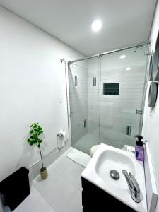 Un baño blanco con ducha y lavabo. en Aparta-Suite en Garagoa ubicación central., en Garagoa