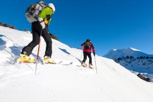 twee mensen zijn aan het skiën op een sneeuw bedekte helling bij Pederü in San Vigilio Di Marebbe