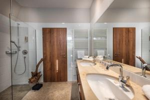 a bathroom with two sinks and a shower at Hotel Eden Rock in Bad Gastein