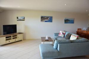 een woonkamer met een bank en een flatscreen-tv bij Jubilee Apartment 04 - Bring your own linen in South West Rocks