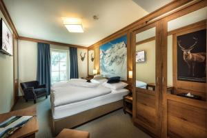 a hotel room with a bed and a chair in it at Hotel Eden Rock in Bad Gastein
