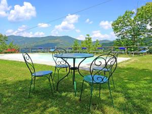 a table and four chairs sitting in the grass at Belvilla by OYO Villa Roseto in Poggioni