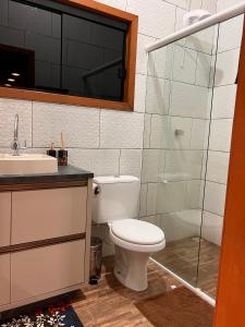 un bagno con wc, lavandino e doccia di Chalé de Pedra a Praia Grande