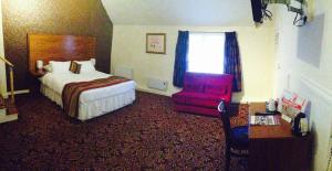 A bed or beds in a room at The Three Tuns Hotel Wetherspoon 