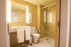 Un baño con inodoro, lavabo y ducha. en Hotel A Pamplona, en Pamplona 37 fotos más