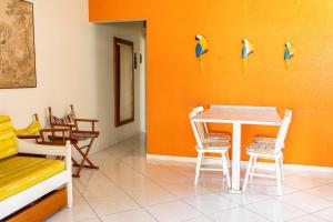 a dining room with a table and chairs and birds on the wall at Residêncial Rosa in Florianópolis