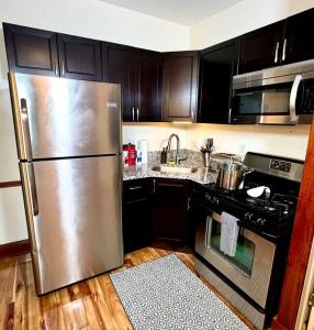 eine Küche mit einem Kühlschrank aus Edelstahl und einem Herd in der Unterkunft The House Hotels - West 47th 1 - Two Bedroom Ohio in Cleveland