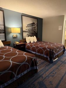 Valued Stay Prairie Du Chien في برايري دو شين: غرفة فندقية بسريرين وصورة على الحائط