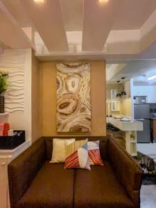 Un sofá con dos almohadas encima en una habitación. en Deryll's Fun house, en Manila