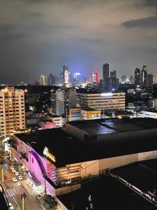 Una vista de una ciudad de noche con edificios. en Deryll's Fun house, en Manila