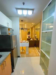 Una cocina con un refrigerador y una mesa dentro. en Deryll's Fun house, en Manila 6 fotos más