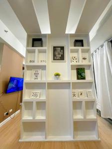 Una estantería blanca en una habitación. en Deryll's Fun house, en Manila