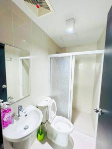 Un baño con inodoro, lavabo y ducha. en Deryll's Fun house, en Manila