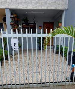 una cerca blanca delante de una casa con un cartel en cantinho da lily, en Balneário Camboriú