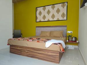 una camera da letto con un letto grande con una parete gialla di Hari Sharnam Home Stay a Mathura