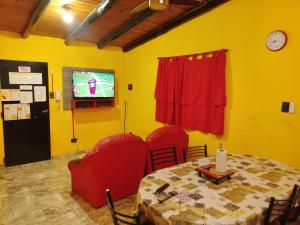 a dining room with a table and chairs and a tv at ALQUILER POR DIA EN MALARGÜE 2 Céntrico in Malargüe