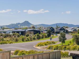 a street in a suburb with houses and a road at Family Casa - Cooks Beach Holiday Home in Cooks Beach