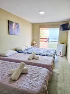 three beds are lined up in a room at Pousada recanto porto tropical in Sirinhaém