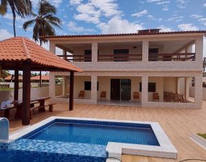 a villa with a swimming pool and a house at Pousada recanto porto tropical in Sirinhaém